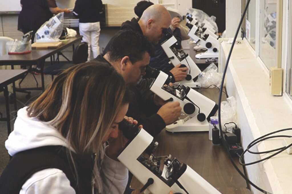 Students in the Optical Assistant Training Program at Martinez Adult Education practice using lensometers.